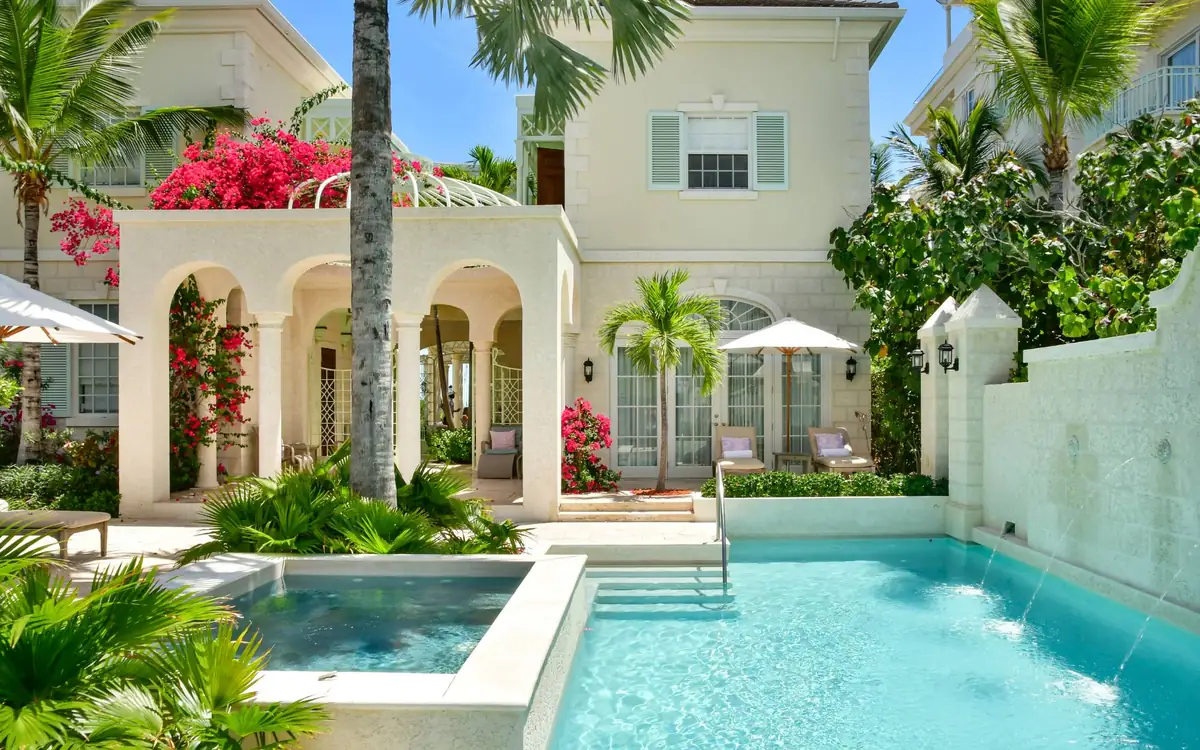 Villa One, façade, arcades et bougainvilliers au bord de la piscine à débordement